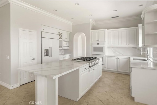 24711 Tiburon St, Valencia, CA 91355 - kitchen featuring open shelves, built in appliances, a kitchen island, light tile patterned floors, and white cabinetry