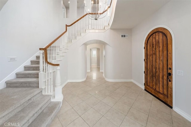 24711 Tiburon St, Valencia, CA 91355 - entrance foyer with arched walkways, light tile patterned floors, stairway, a chandelier, and a high ceiling