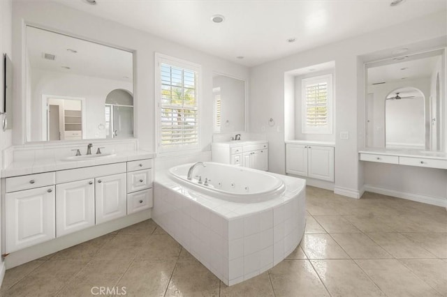 24711 Tiburon St, Valencia, CA 91355 - bathroom with tile patterned floors, a tub with jets, two vanities, and healthy amount of natural light