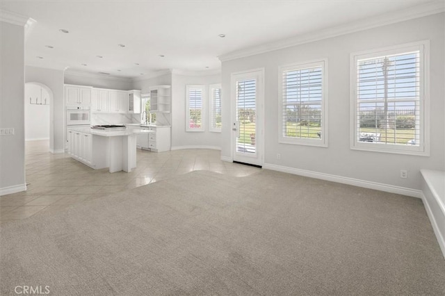 24711 Tiburon St, Valencia, CA 91355 - kitchen with white oven, crown molding, light tile patterned floors, light carpet, and white cabinetry