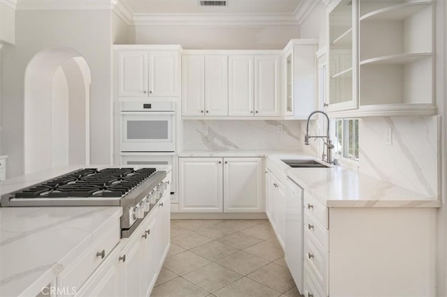 24711 Tiburon St, Valencia, CA 91355 - kitchen with stainless steel gas cooktop, ornamental molding, light stone counters, white cabinets, and backsplash