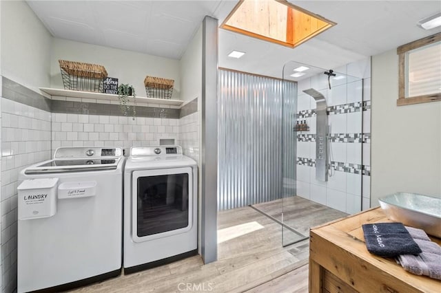 310 Teakwood Dr, Big Bear Lake, CA 92315 - laundry room featuring tile walls, washer and clothes dryer, and light wood-style floors