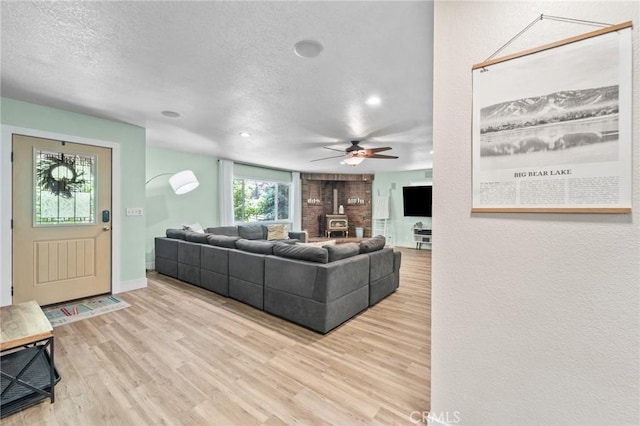 310 Teakwood Dr, Big Bear Lake, CA 92315 - living area with a textured ceiling, wood finished floors, a ceiling fan, a wood stove, and recessed lighting