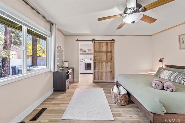 310 Teakwood Dr, Big Bear Lake, CA 92315 - bedroom featuring separate washer and dryer, light wood-style flooring, crown molding, a barn door, and a ceiling fan