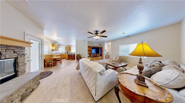 12443 Bannock Dr, Apple Valley, CA 92308 - living room with a stone fireplace, light colored carpet, ceiling fan, and a textured ceiling