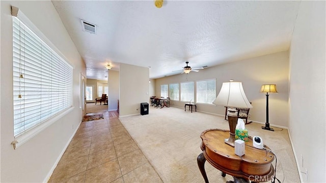 12443 Bannock Dr, Apple Valley, CA 92308 - living area with light carpet, light tile patterned floors, and a ceiling fan