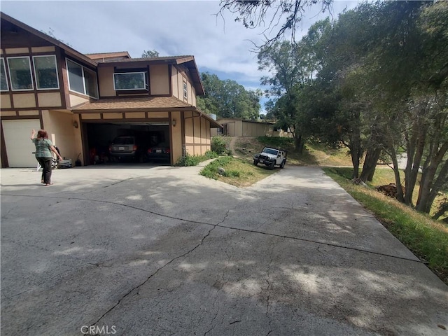 535 N Dart Canyon Rd, Crestline, CA 92325 - view of side of home with concrete driveway, a garage, and stucco siding