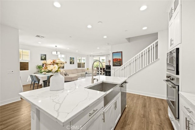 12260 Chorus Dr, Rancho Cucamonga, CA 91739 - kitchen featuring stainless steel appliances, recessed lighting, a kitchen island with sink, white cabinets, and dark wood finished floors