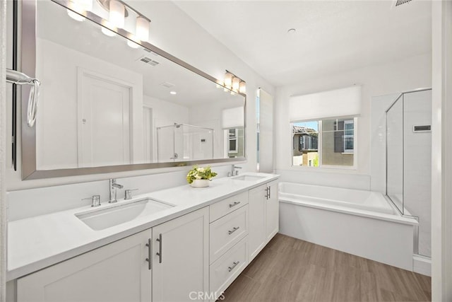 12260 Chorus Dr, Rancho Cucamonga, CA 91739 - bathroom with a bath, a shower stall, double vanity, and wood finished floors