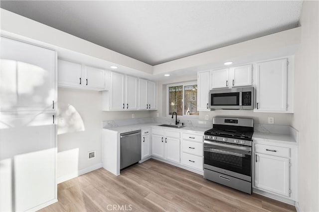 36829 Burroughs Way, Palmdale, CA 93552 - kitchen with appliances with stainless steel finishes, white cabinets, recessed lighting, light countertops, and light wood-style floors