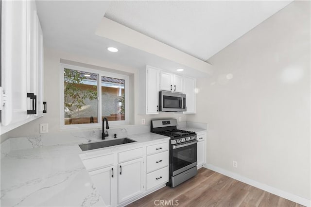 36829 Burroughs Way, Palmdale, CA 93552 - kitchen with stainless steel appliances, white cabinetry, light stone countertops, recessed lighting, and light wood-style floors