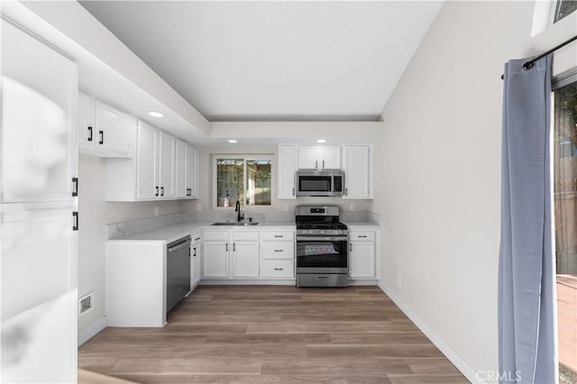 36829 Burroughs Way, Palmdale, CA 93552 - kitchen with stainless steel appliances, white cabinets, light wood-type flooring, and recessed lighting