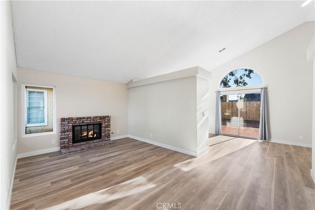 36829 Burroughs Way, Palmdale, CA 93552 - unfurnished living room with wood finished floors, a brick fireplace, and high vaulted ceiling