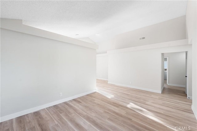 36829 Burroughs Way, Palmdale, CA 93552 - empty room featuring lofted ceiling, light wood-style flooring, and a textured ceiling