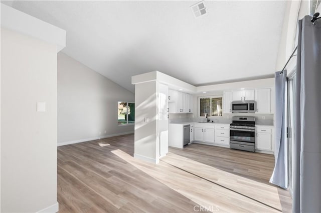 36829 Burroughs Way, Palmdale, CA 93552 - kitchen featuring appliances with stainless steel finishes, white cabinetry, light countertops, open floor plan, and lofted ceiling