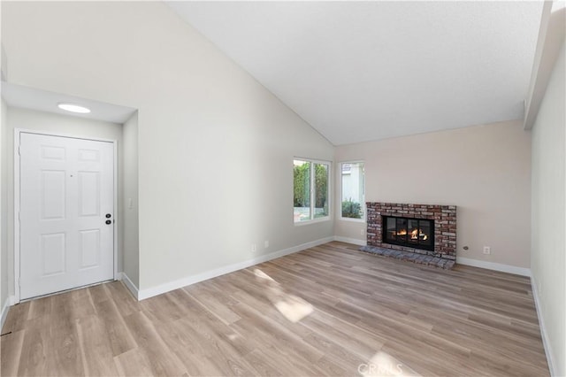 36829 Burroughs Way, Palmdale, CA 93552 - unfurnished living room with high vaulted ceiling, light wood-style flooring, and a brick fireplace