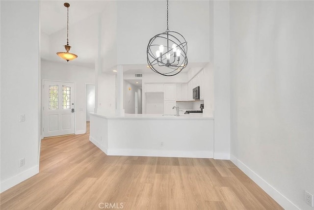 2914 Crape Myrtle Cir, Chino Hills, CA 91709 - unfurnished living room featuring light wood finished floors, a chandelier, and a towering ceiling