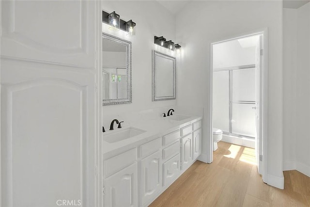 2914 Crape Myrtle Cir, Chino Hills, CA 91709 - bathroom featuring wood finished floors, a shower with shower door, and double vanity
