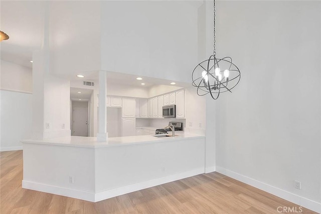 2914 Crape Myrtle Cir, Chino Hills, CA 91709 - kitchen featuring stainless steel microwave, range, a peninsula, light countertops, and a towering ceiling