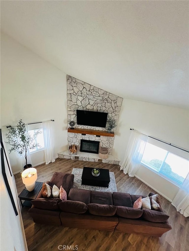 13330 Tamarisk Rd, Victorville, CA 92395 - living room featuring lofted ceiling, a fireplace, and wood finished floors