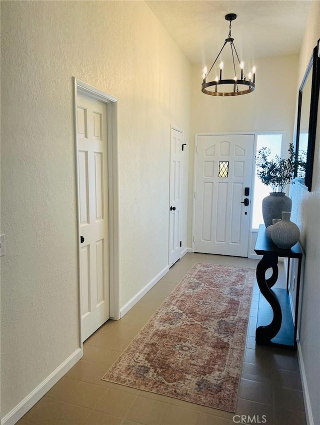 13330 Tamarisk Rd, Victorville, CA 92395 - foyer entrance featuring a chandelier, a textured wall, and tile patterned floors