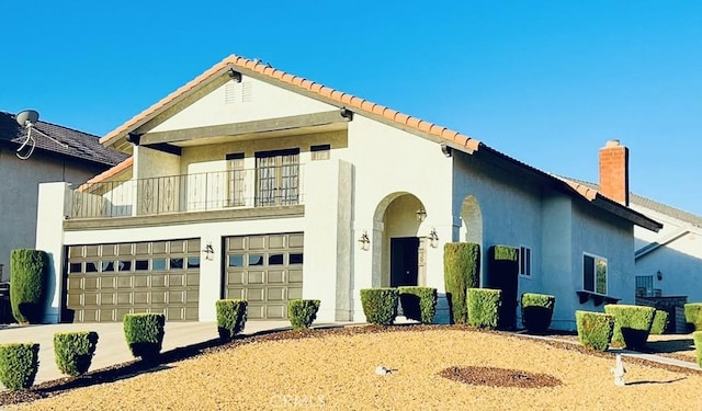 13330 Tamarisk Rd, Victorville, CA 92395 - view of front of house with a balcony, stucco siding, a tile roof, an attached garage, and a chimney