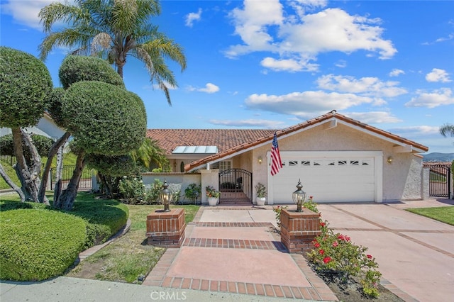 2039 Channelford Rd, Westlake Village, CA 91361 - mediterranean / spanish home featuring a gate, a garage, stucco siding, concrete driveway, and a tile roof