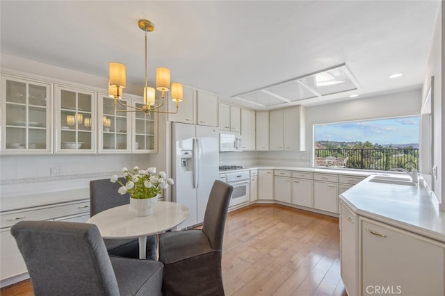 2039 Channelford Rd, Westlake Village, CA 91361 - kitchen featuring white appliances, a chandelier, light wood-type flooring, glass insert cabinets, and light countertops