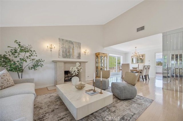 2039 Channelford Rd, Westlake Village, CA 91361 - living room featuring a chandelier, high vaulted ceiling, light wood-style floors, and a premium fireplace