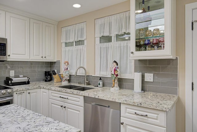 271 Avenida Sevilla Unit P, Laguna Woods, CA 92637 - kitchen featuring appliances with stainless steel finishes, white cabinets, tasteful backsplash, light stone counters, and recessed lighting