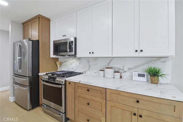 4203 Tolowa St, San Diego, CA 92117 - kitchen with appliances with stainless steel finishes, backsplash, light stone counters, light wood-style flooring, and white cabinets