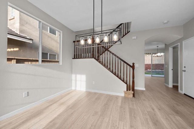 1347 Vallejo Mills St, Chula Vista, CA 91913 - unfurnished living room with a chandelier, wood finished floors, arched walkways, and stairway