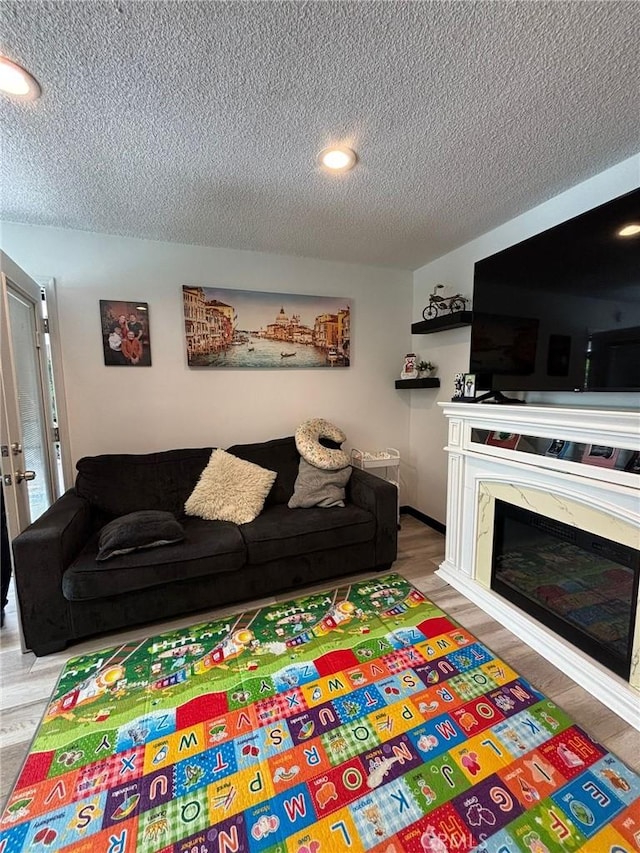 2835 Etiwanda Ave, Rialto, CA 92376 - living room with a textured ceiling, a glass covered fireplace, wood finished floors, and recessed lighting