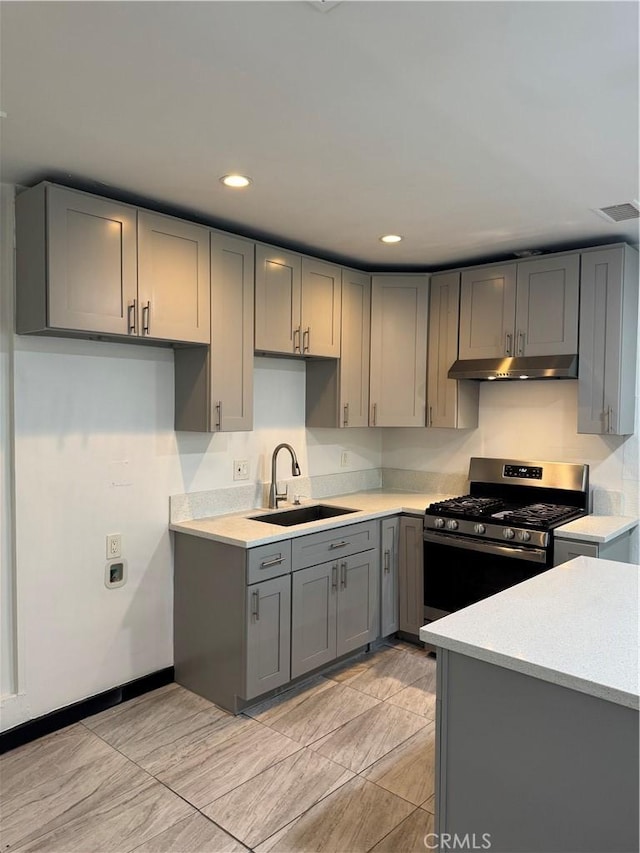 2835 Etiwanda Ave, Rialto, CA 92376 - kitchen featuring under cabinet range hood, stainless steel gas range oven, gray cabinetry, light countertops, and recessed lighting