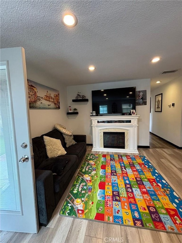 2835 Etiwanda Ave, Rialto, CA 92376 - living room with wood finished floors, a textured ceiling, recessed lighting, and a premium fireplace