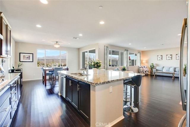 35212 Smith Ave, Beaumont, CA 92223 - kitchen featuring stainless steel dishwasher, dark wood-style flooring, recessed lighting, a kitchen island with sink, and a breakfast bar