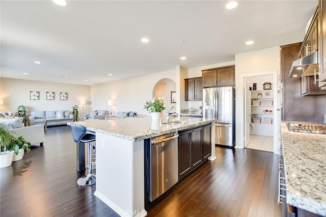 35212 Smith Ave, Beaumont, CA 92223 - kitchen with stainless steel appliances, under cabinet range hood, open floor plan, dark wood finished floors, and an island with sink