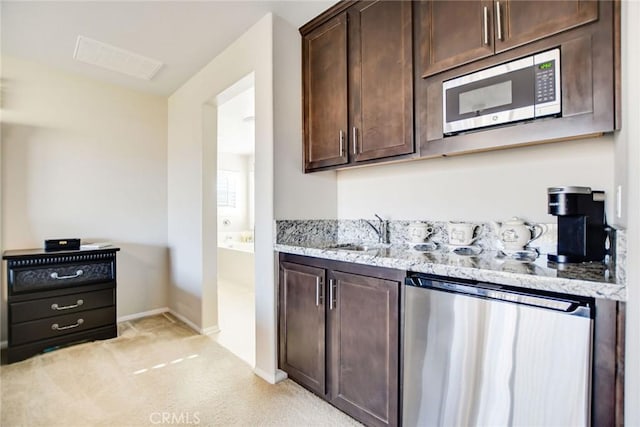 35212 Smith Ave, Beaumont, CA 92223 - kitchen featuring stainless steel appliances, dark brown cabinets, light colored carpet, and light stone countertops