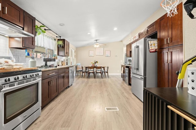 1067 Stevenson St Unit A & B, Colton, CA 92324 - kitchen featuring appliances with stainless steel finishes, under cabinet range hood, light wood finished floors, a ceiling fan, and decorative backsplash