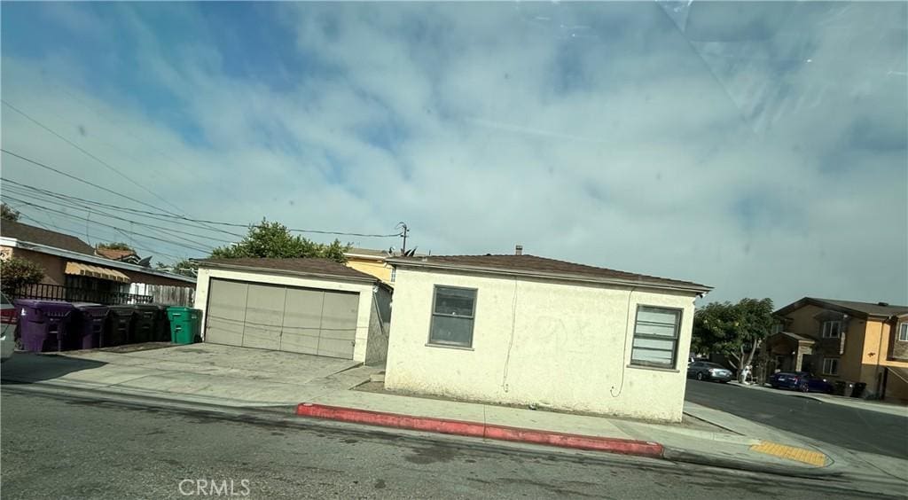 358 E 53rd St, Long Beach, CA 90805 - view of side of property with stucco siding, an outbuilding, and a garage