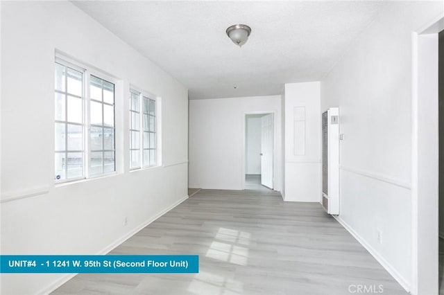 1241 W 95th St, Los Angeles, CA 90044 - spare room with a heating unit, wood finished floors, and a textured ceiling