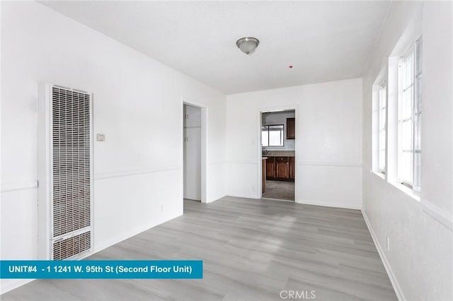 1241 W 95th St, Los Angeles, CA 90044 - empty room featuring a heating unit and light wood-style floors