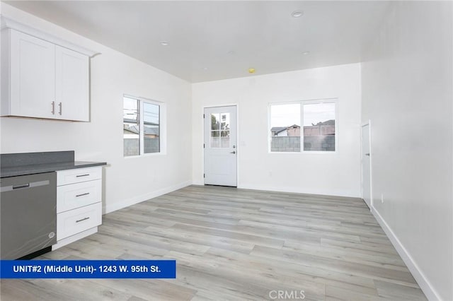 1241 W 95th St, Los Angeles, CA 90044 - kitchen featuring dishwasher, light wood-style flooring, white cabinetry, and healthy amount of natural light