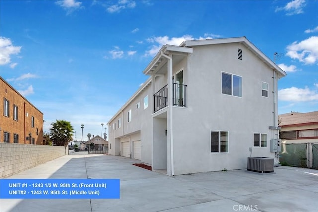 1241 W 95th St, Los Angeles, CA 90044 - back of house featuring a balcony, stucco siding, a garage, and concrete driveway