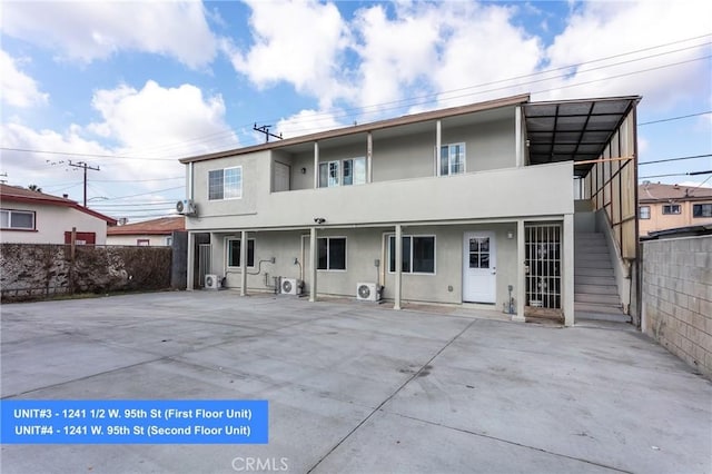 1241 W 95th St, Los Angeles, CA 90044 - rear view of house featuring stairway and stucco siding