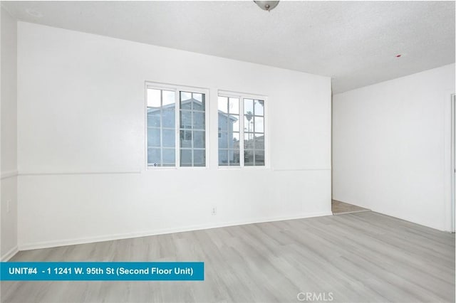 1241 W 95th St, Los Angeles, CA 90044 - spare room featuring wood finished floors and a textured ceiling