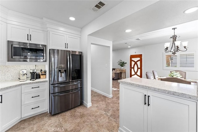 2901 Huston St, Pomona, CA 91767 - kitchen featuring stainless steel appliances, white cabinets, recessed lighting, a chandelier, and light stone counters