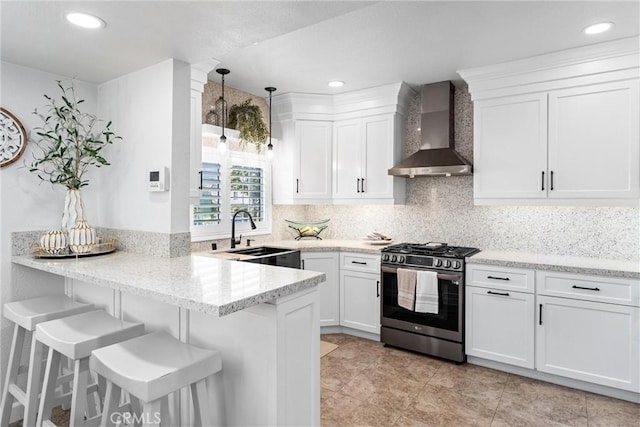 2901 Huston St, Pomona, CA 91767 - kitchen with stainless steel range with gas stovetop, wall chimney range hood, a peninsula, white cabinetry, and recessed lighting