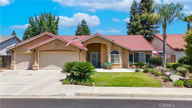 1115 Chennault Ave, Clovis, CA 93611 - mediterranean / spanish-style house featuring stucco siding, an attached garage, a tile roof, and driveway