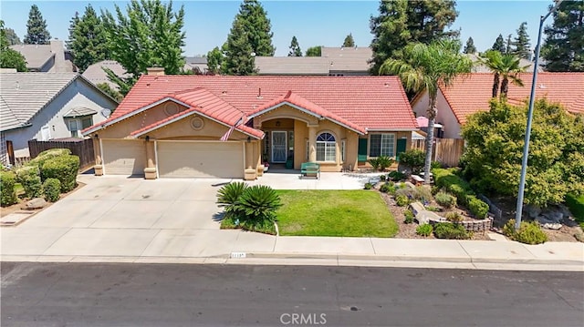 1115 Chennault Ave, Clovis, CA 93611 - mediterranean / spanish-style home featuring a tile roof, an attached garage, stucco siding, and concrete driveway